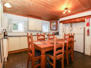 uma cozinha com uma mesa de jantar em madeira e cadeiras em Is Y Graig em Caernarfon