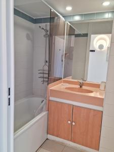 a bathroom with a sink and a tub and a mirror at Magnifique vue mer et piscine - Les Clés de L Estérel in Théoule-sur-Mer