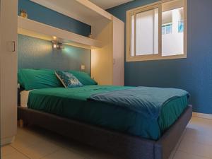 um quarto com uma cama com lençóis verdes e uma janela em Magnifique vue mer et piscine - Les Clés de L Estérel em Théoule-sur-Mer