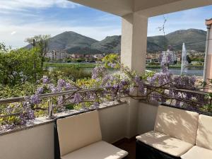 un balcón con 2 sillas y flores púrpuras en VILLA OTOK WITH POOL, TOP LUXURY IN TREBINJE en Trebinje