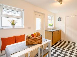 a kitchen with a table with a basket of fruit on it at 4 Bed in Hornsea 89887 in Hornsea