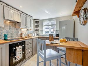 a kitchen with a table and chairs and a refrigerator at 4 Bed in Sea Palling 89919 in Sea Palling