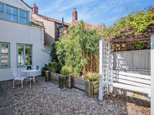 a garden with a bench in front of a house at 4 Bed in Sea Palling 89919 in Sea Palling