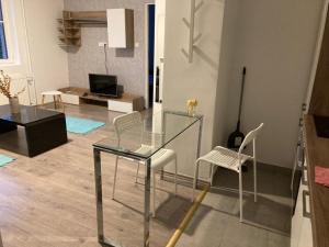 a glass table and chairs in a living room at City Center Superb inside 3 Bedroom+Living room Apartment in Szombathely