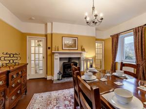 a dining room with a table and a fireplace at 3 Bed in Alston 89994 in Slaggyford