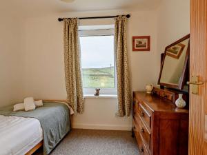 a bedroom with a bed and a window and a dresser at 3 Bed in Alston 89994 in Slaggyford