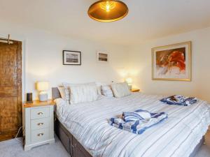 sypialnia z dużym łóżkiem z niebieską i białą pościelą w obiekcie 3 Bed in Appledore 89953 w mieście Appledore