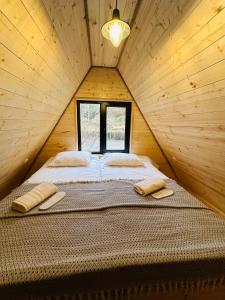 Bett in einem Holzzimmer mit Fenster in der Unterkunft Hilltop Glola in Glola