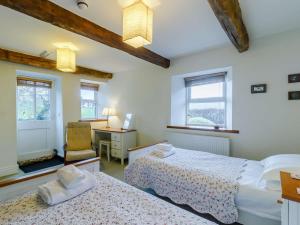 una camera con 2 letti, una scrivania e una sedia di 4 Bed in Abergavenny 90003 a Gilwern