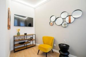 Habitación con silla amarilla y espejos en la pared. en Plaza Mayor cozy Private apartment with AC, en Madrid