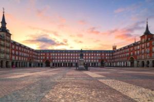 un gran edificio con una puesta de sol en el fondo en Plaza Mayor cozy Private apartment with AC, en Madrid