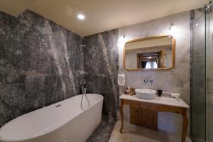 a bathroom with a tub and a sink and a mirror at Luxury Cratus Stone Palace in Goreme