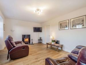 a living room with leather furniture and a fireplace at 2 Bed in Ayr 90039 in Ayr