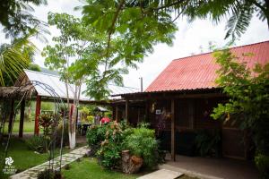 una casa con techo rojo y algunas plantas en La Cabaña de Blanca, en Jalpan