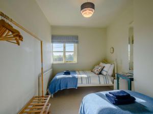 1 Schlafzimmer mit 2 Betten und einem Fenster in der Unterkunft 3 Bed in Sedgeford 90011 in Sedgeford