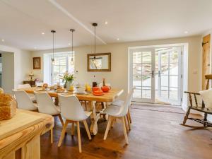 una cucina e una sala da pranzo con tavolo e sedie in legno di 5 Bed in Crickhowell 90053 a Crickhowell