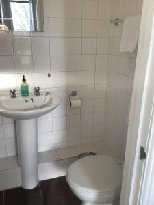 a white bathroom with a toilet and a sink at The Riverside in Sutton Bridge