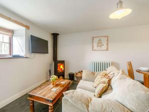 ein Wohnzimmer mit einem Sofa und einem Tisch in der Unterkunft 1 Bed in Newquay 89942 in Mawgan Porth