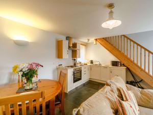 a kitchen and dining room with a table and a couch at 1 Bed in Newquay 89942 in Mawgan Porth