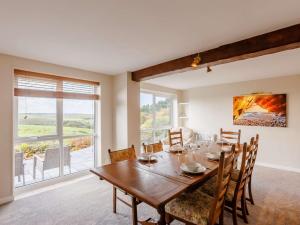 una sala da pranzo con un grande tavolo in legno e sedie di 5 Bed in Widemouth Bay 89900 a Week Saint Mary