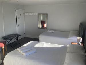 2 Betten in einem Hotelzimmer mit Handtüchern darauf in der Unterkunft The Riverside in Sutton Bridge