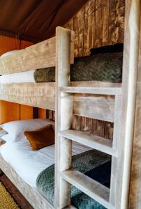 מיטה או מיטות קומותיים בחדר ב-Fibden Farm Glamping - Luxury Safari Lodge