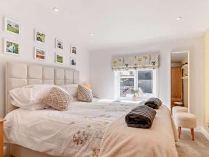 ein weißes Schlafzimmer mit einem großen Bett mit Kissen darauf in der Unterkunft 3 Bed in Amberley 89898 in Woodchester