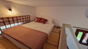 a bedroom with a bed with red pillows on it at Seva Monolithos house in Monólithos