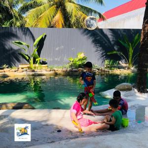 un grupo de niños jugando en el agua en una piscina en Cóc Retreat Mỹ Tho City, en Mỹ Tho
