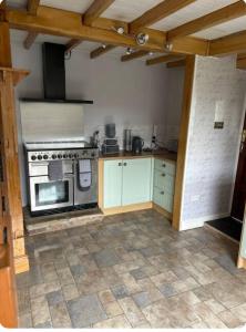 a kitchen with a stove top oven in a room at Cosy Cottage in Knottingly