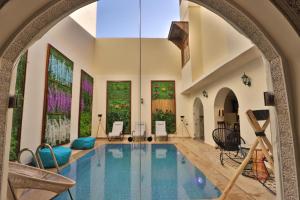 una piscina cubierta en una casa con un arco en Darif's Riad & Spa en Fez