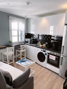 a kitchen with black and white appliances in a room at Fabulous City Centre Apartment - Grand Central House in Gibraltar