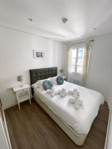 a bedroom with a bed with white sheets and blue pillows at Fabulous City Centre Apartment - Grand Central House in Gibraltar