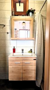 a bathroom with a sink and a mirror at Seva Monolithos house in Monólithos