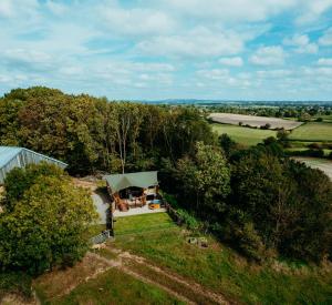 una vista in alto di una casa in mezzo a un campo di Fibden Farm Glamping - Luxury Safari Lodge a Droitwich