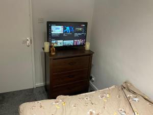 a television sitting on a dresser in a bedroom at Feel at home in Abbey Wood