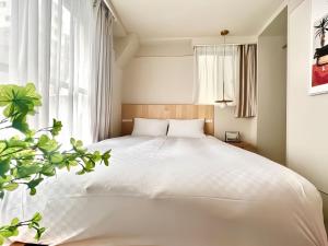 1 dormitorio con cama blanca y ventana en 上野超豪华4人间 东京超级中心Ydoa 设计师房间 上野公园3分钟 车站1分钟 超级繁华 免费wifi 戴森吹风, en Tokio