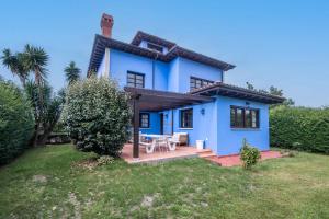 uma casa azul com uma mesa de piquenique no quintal em Llanes: Casa Azul de Pancar em Pancar