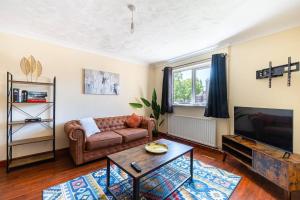 a living room with a couch and a tv at Cosy Three Bed Close to City Centre with Free Parking in Ipswich