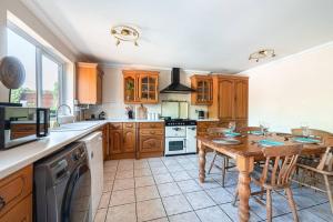a large kitchen with a wooden table and a dining room at Cosy 3-Bed Close to City Centre with Free Parking in Ipswich