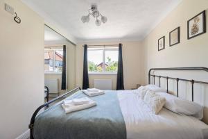 a bedroom with a bed with two towels on it at Cosy 3-Bed Close to City Centre with Free Parking in Ipswich
