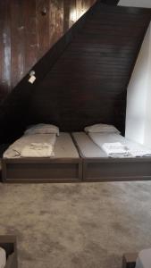 a bed in a room under a staircase at Vučko apartmani Konaci in Kopaonik
