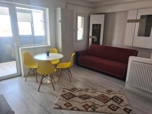 a living room with a couch and a table and chairs at Luxury Mall Q4 Apartment in Bacău