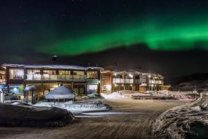 a hotel with the aurora in the sky w obiekcie Katterjåkk Apartments w mieście Riksgränsen