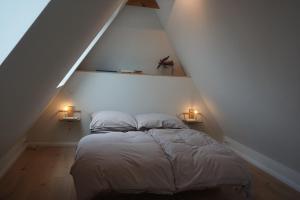 Un dormitorio con una cama con dos luces. en Ostseeloft, en Flensburg