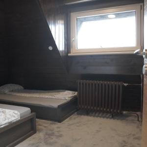 a room with two beds and a window at Vučko apartmani Konaci in Kopaonik