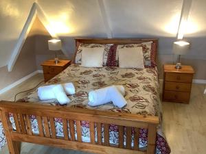 um quarto com uma cama de madeira e 2 almofadas em Haelarcher Farmhouse and Helicopter B&B em Lizard