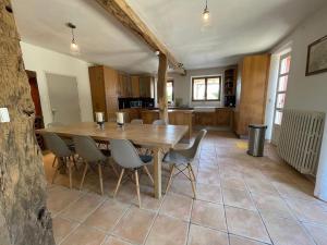 cocina y comedor con mesa de madera y sillas en Luxurious Villa in Cazaubon with Swimming Pool, en Marguestau