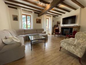 ein Wohnzimmer mit einem Sofa und einem Tisch in der Unterkunft Luxurious Villa in Cazaubon with Swimming Pool in Marguestau