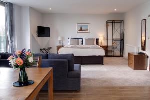 a hotel room with a bed and a living room at Cotswolds Hotel & Spa in Chipping Norton